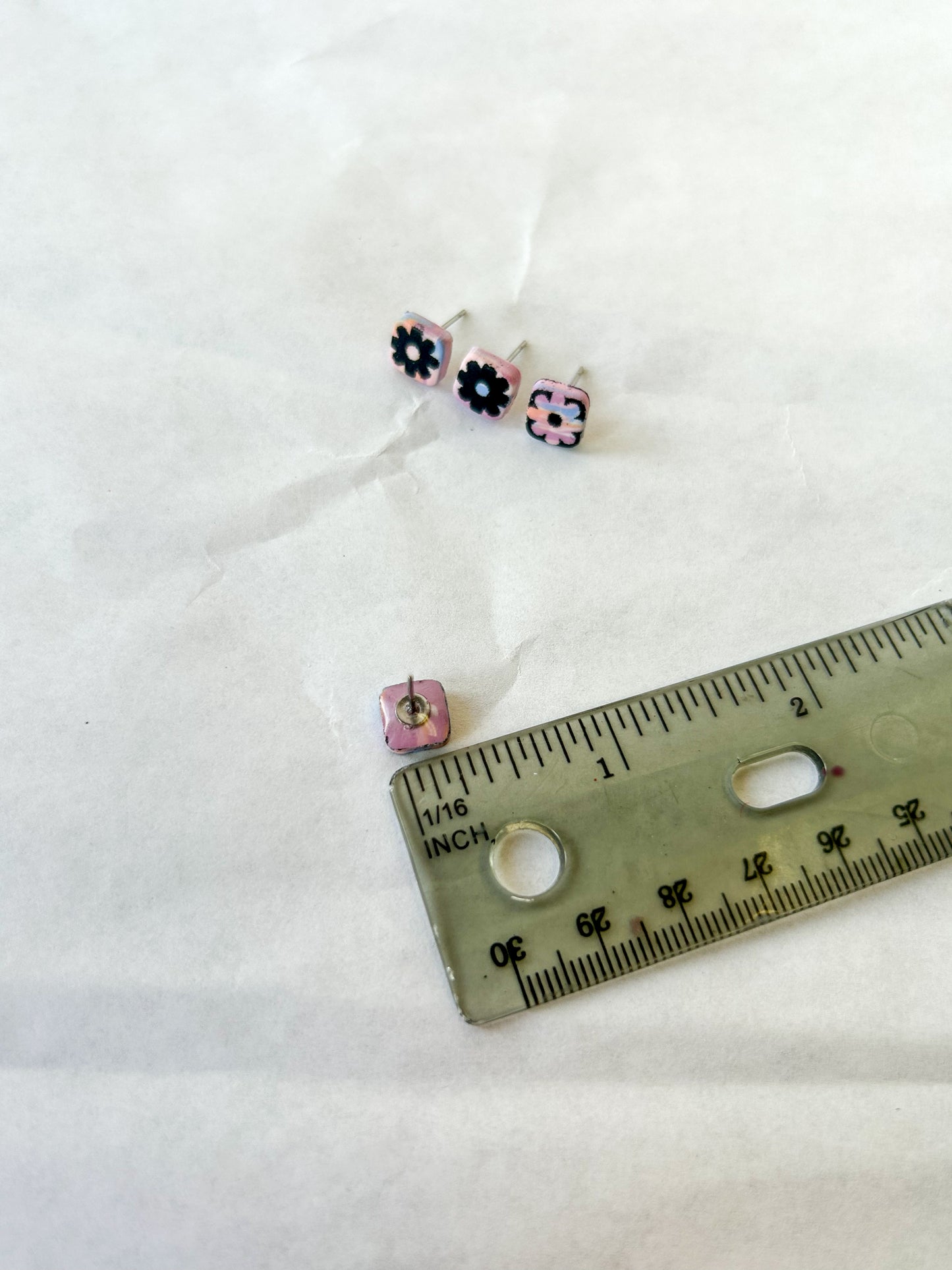 Stud earring next to a ruler to show that it is 1/4 inch in length