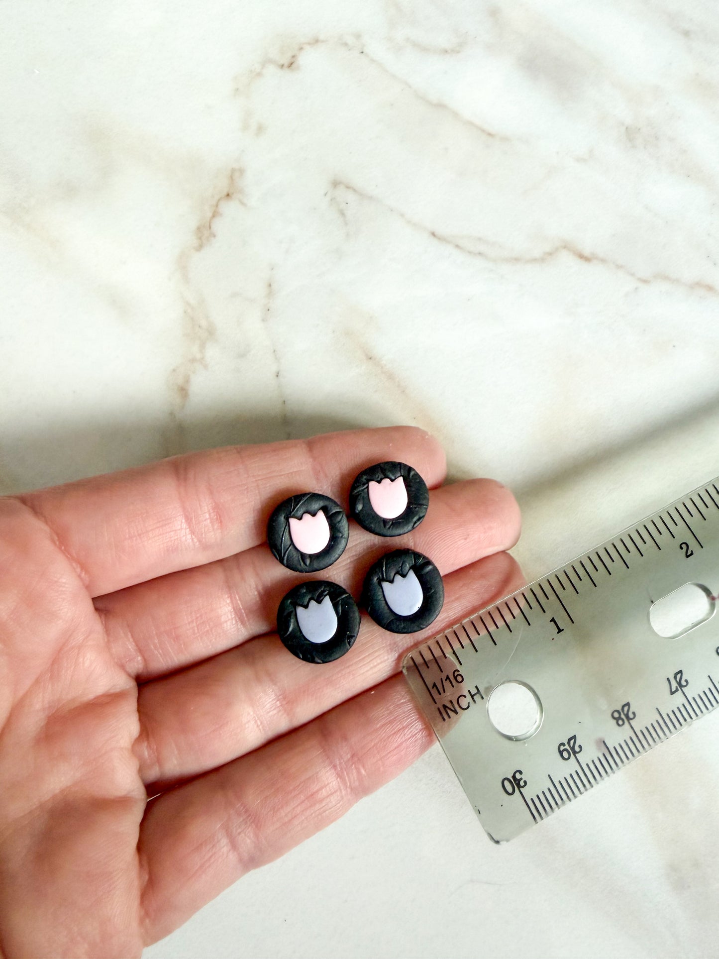 Studs held against a ruler for scale. About 1cm in width