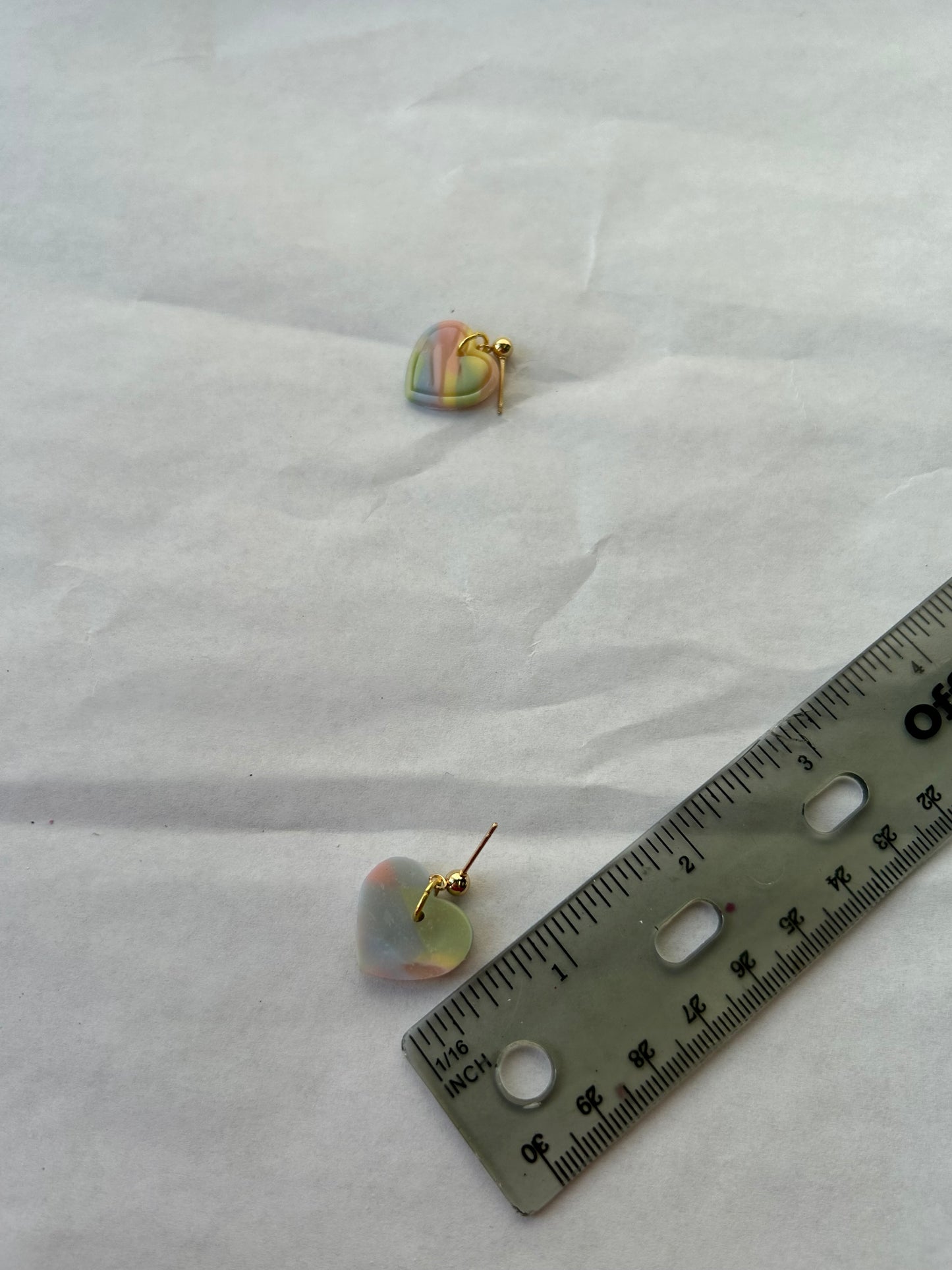 Pair of earrings with a ruler for scale on a white background
1 inch in length