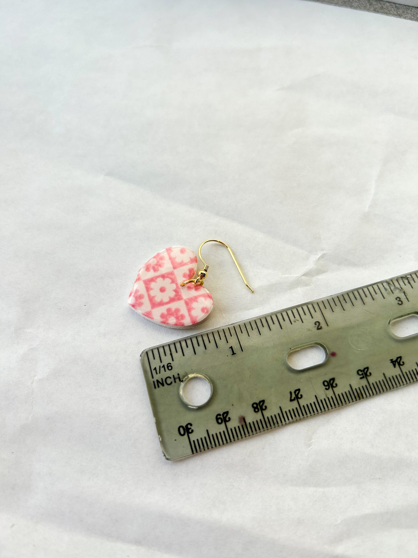 Earrings laying next to a ruler for a scale to show that they are one and a half inches long