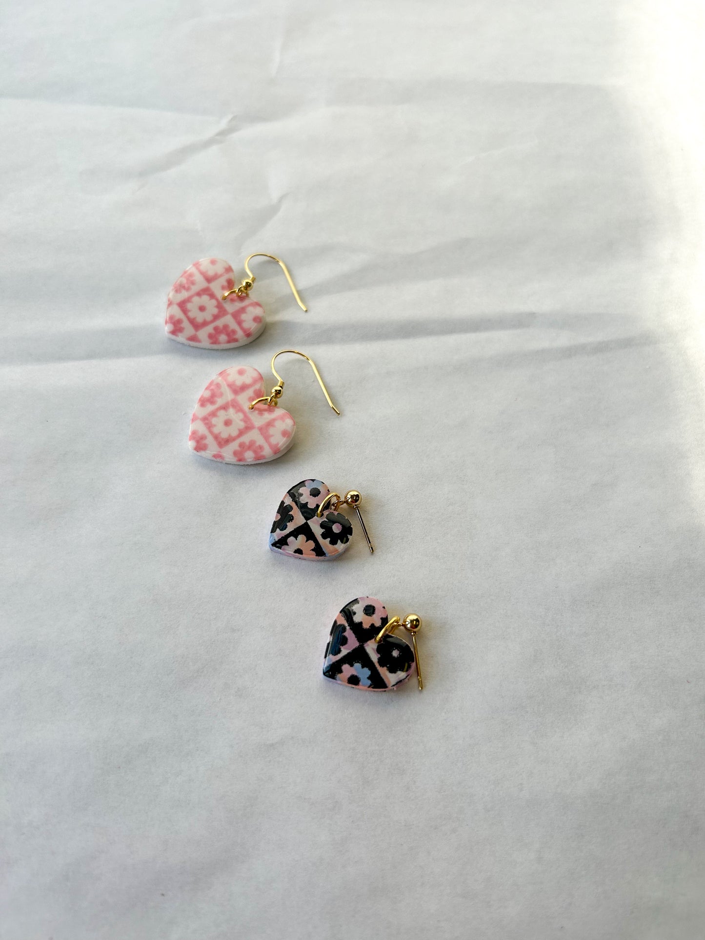 Two pairs of earrings laying on a flat surface