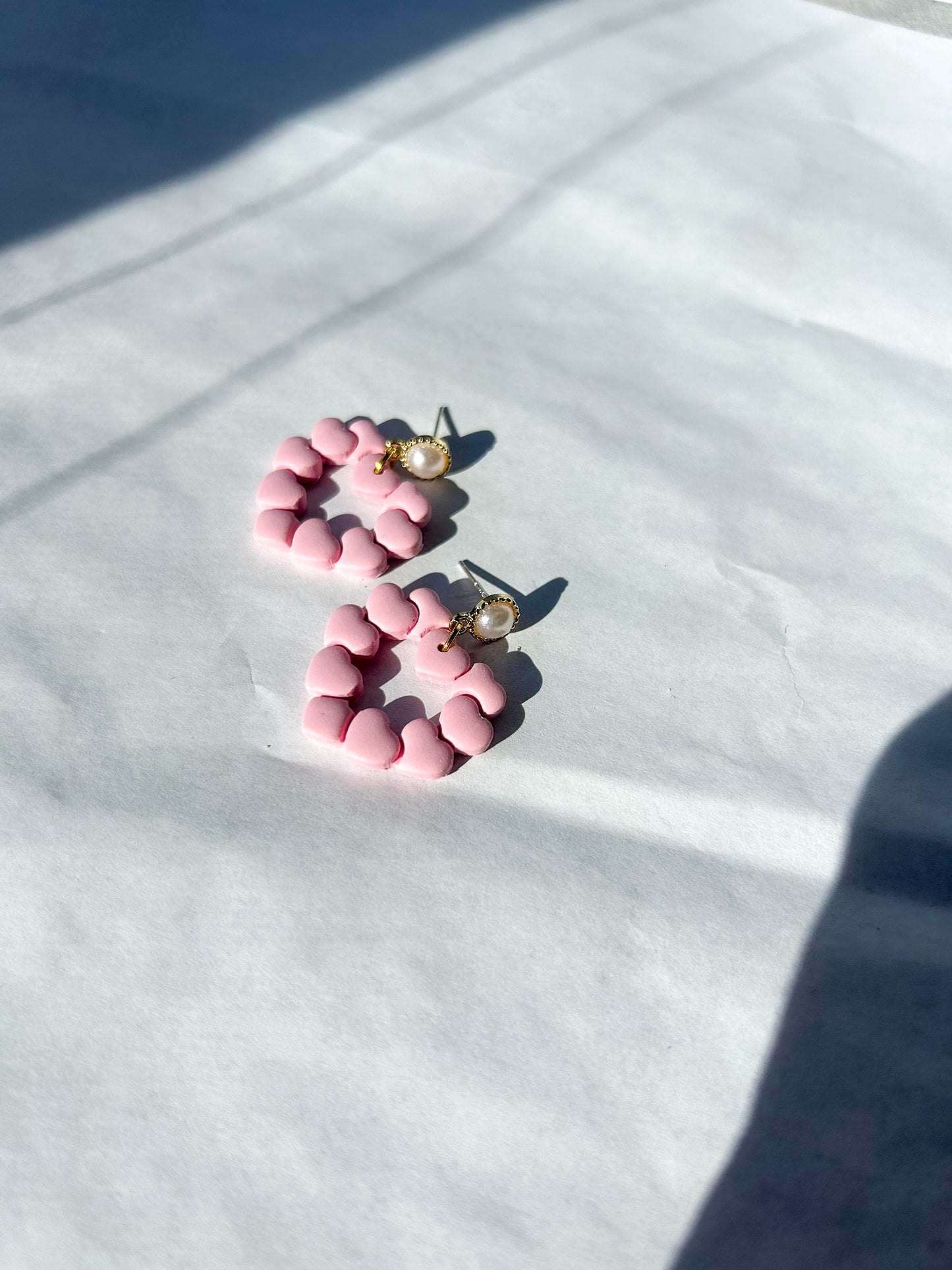 Pink heart earrings on a white background