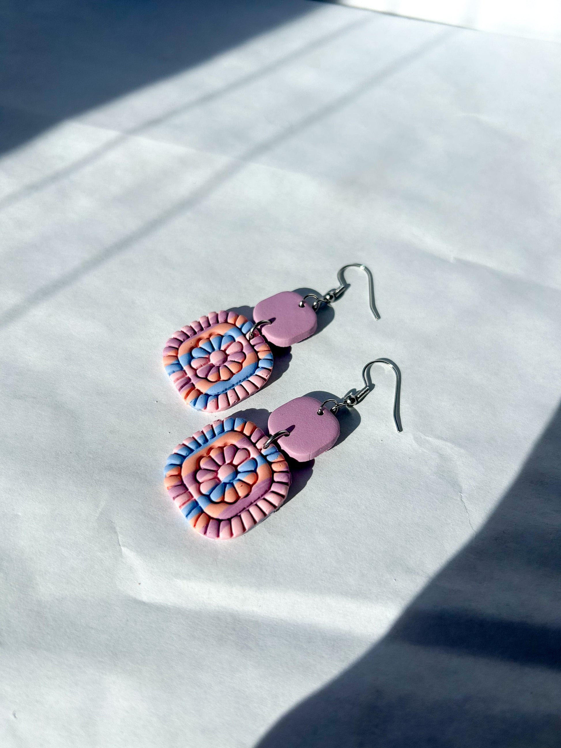 Colorful earrings on a white surface