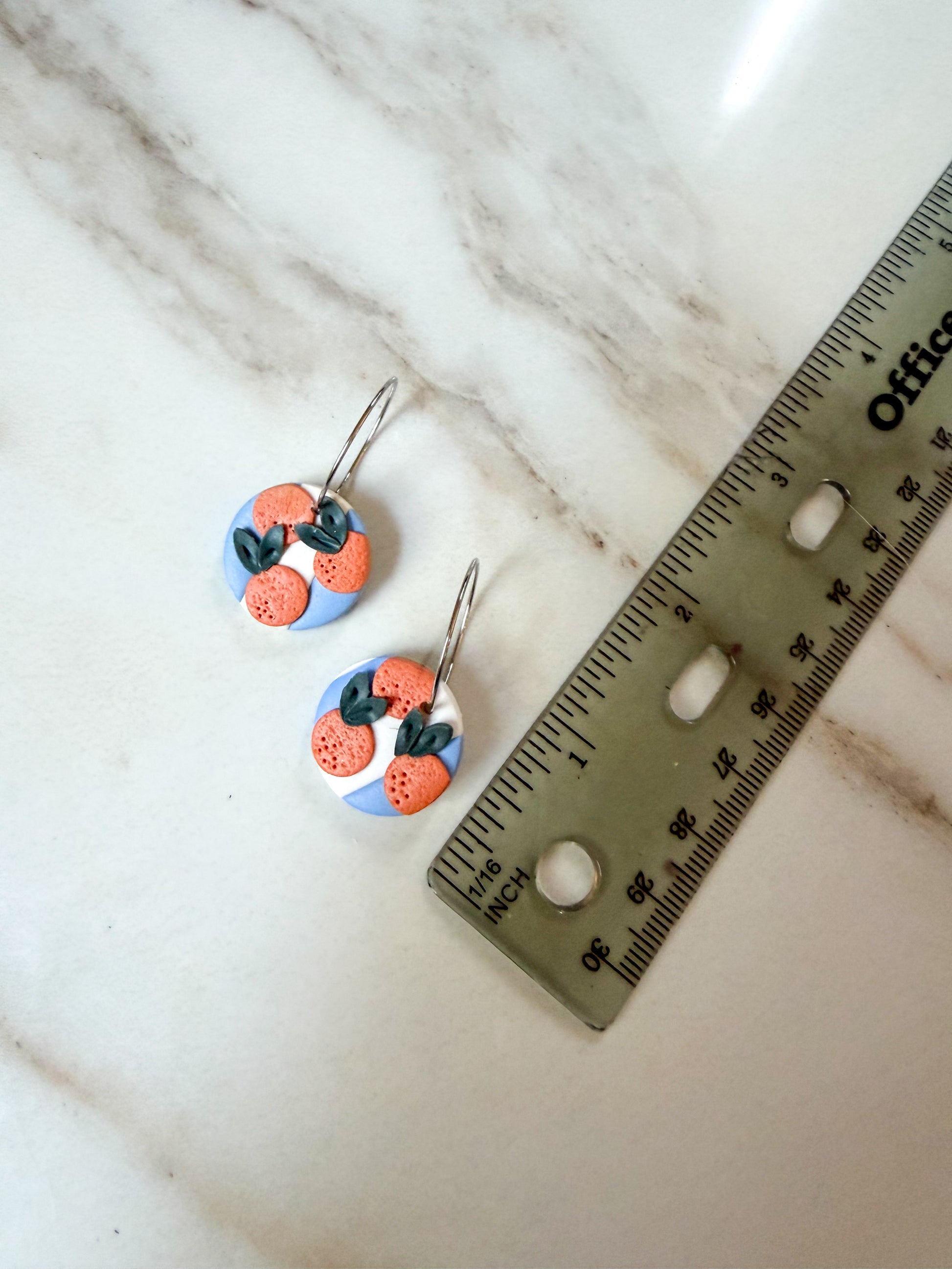 A pair of blue and white stripe dangles with oranges on top. A little over an inch in length. 