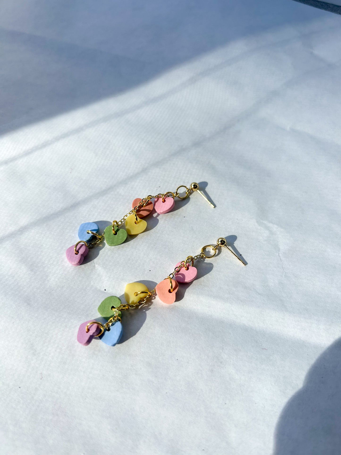 Colorful earrings on a white fabric background