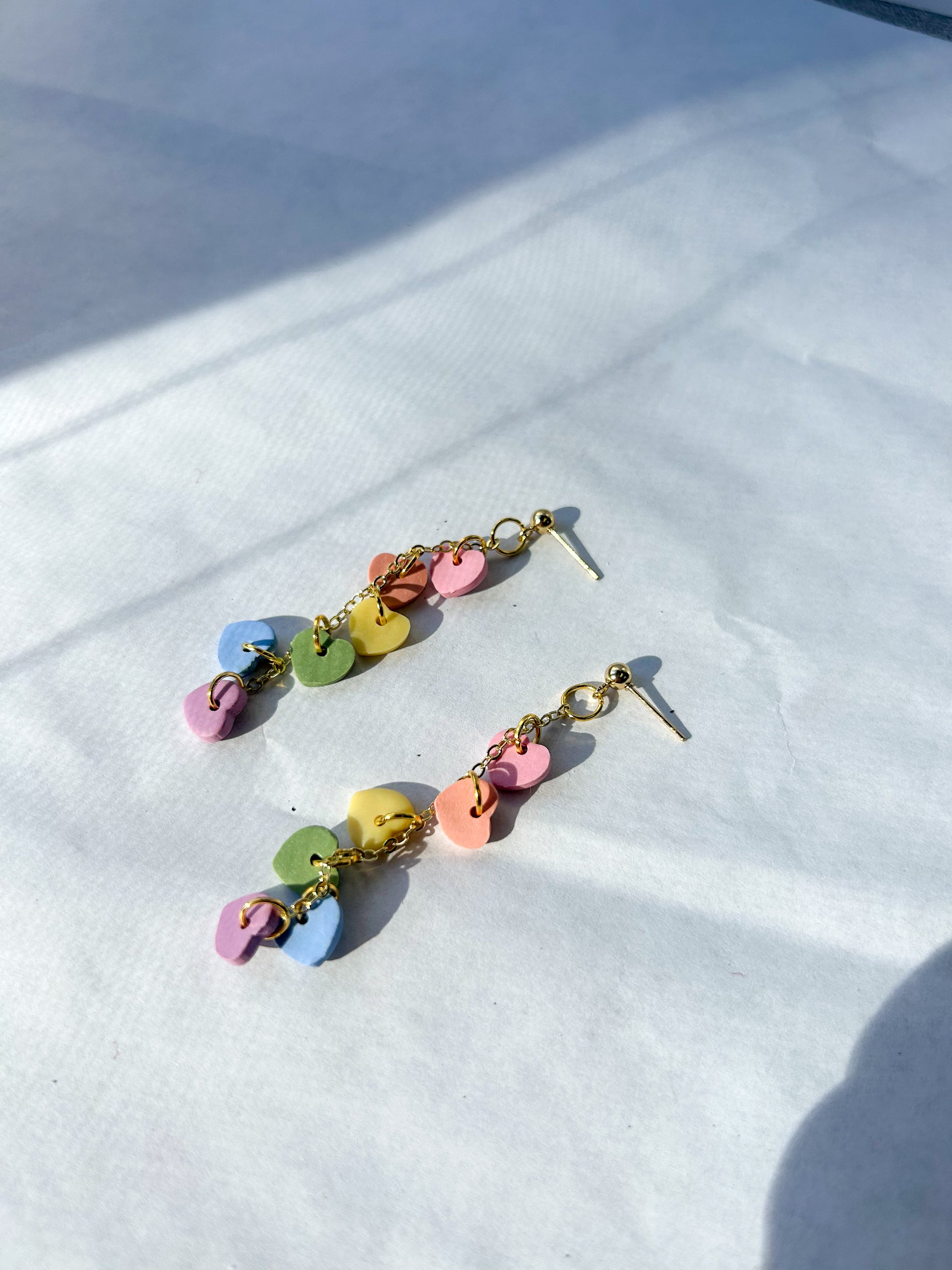 Colorful earrings on a white fabric background