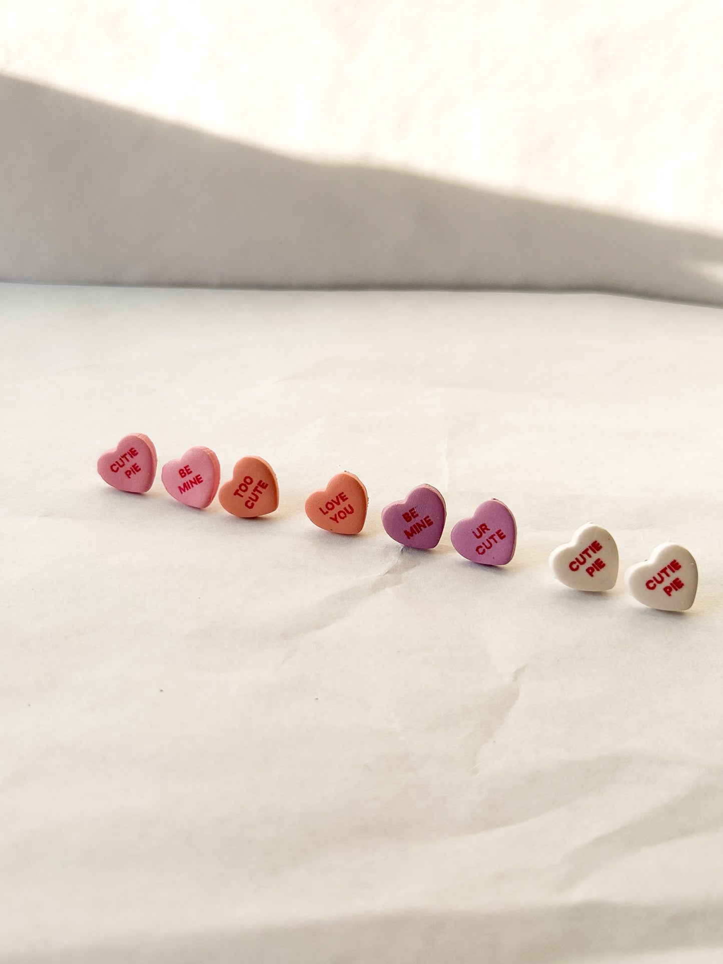 Candy heart studs laying next to each other on a flat surface