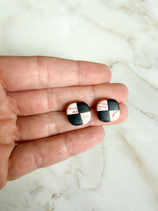 Checker studs held between fingers on a marble surface