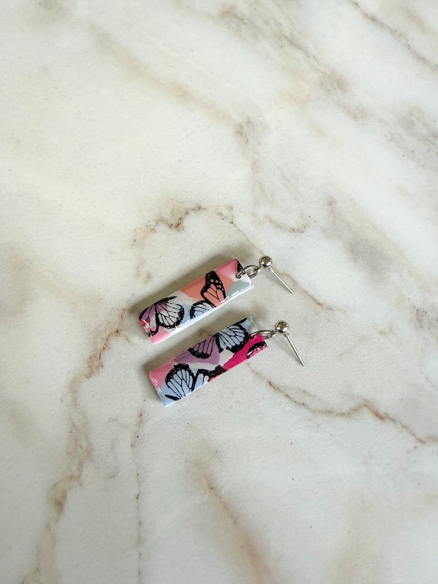 Butterfly-patterned earrings on a marble surface