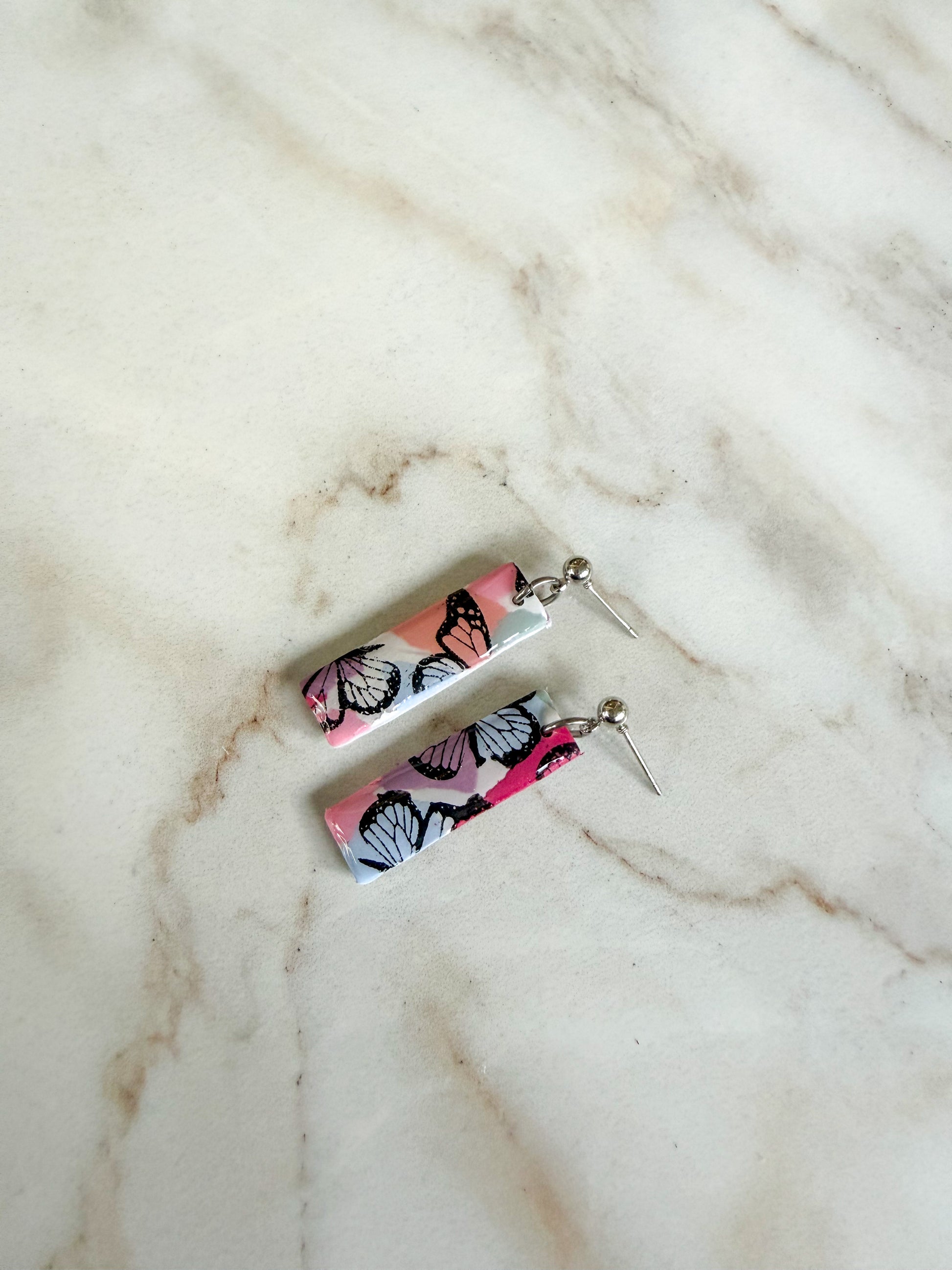 Butterfly-patterned earrings on a marble surface