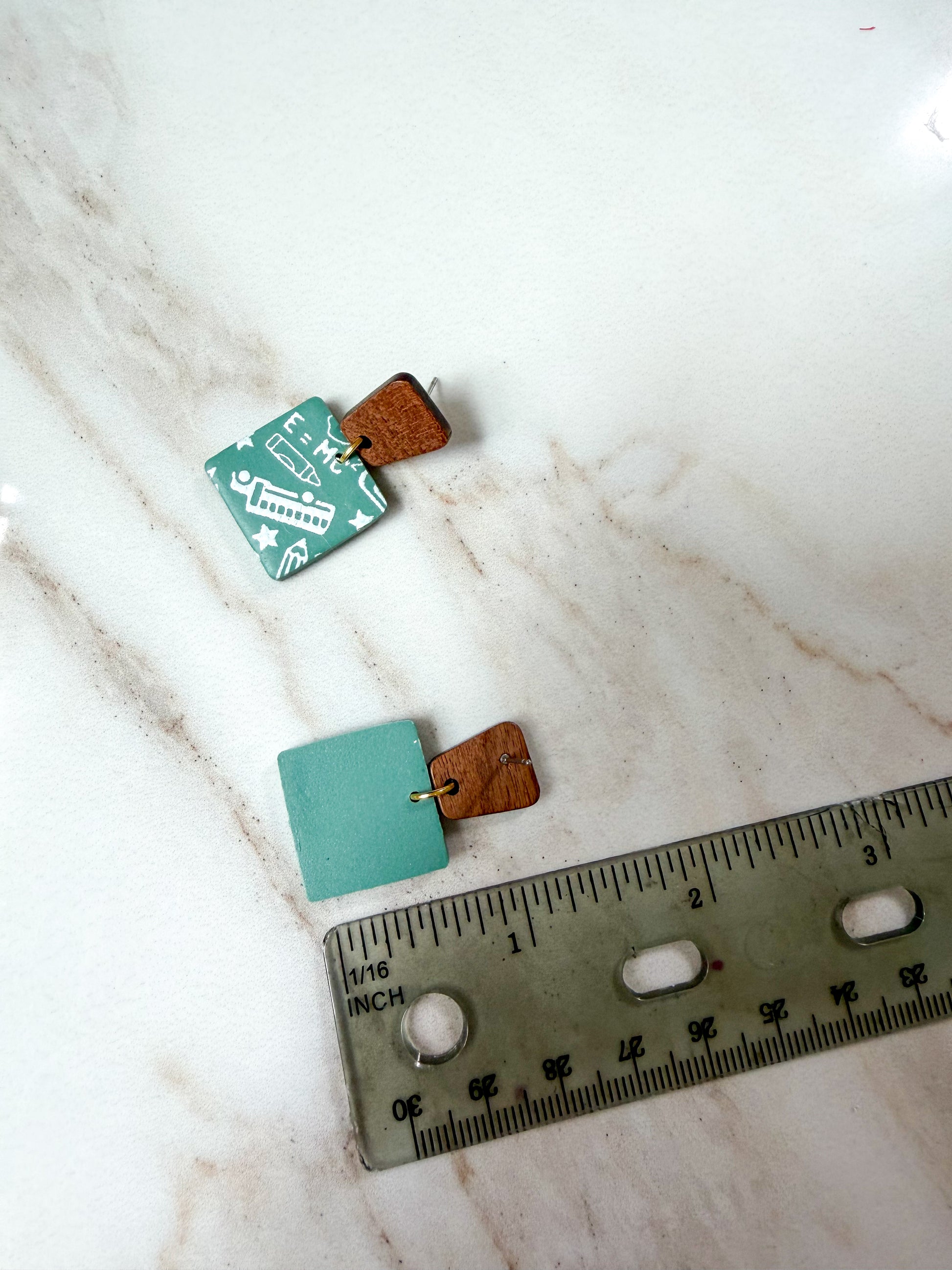 The smaller earring against a ruler for scale. About 1 1/4 inches long. 