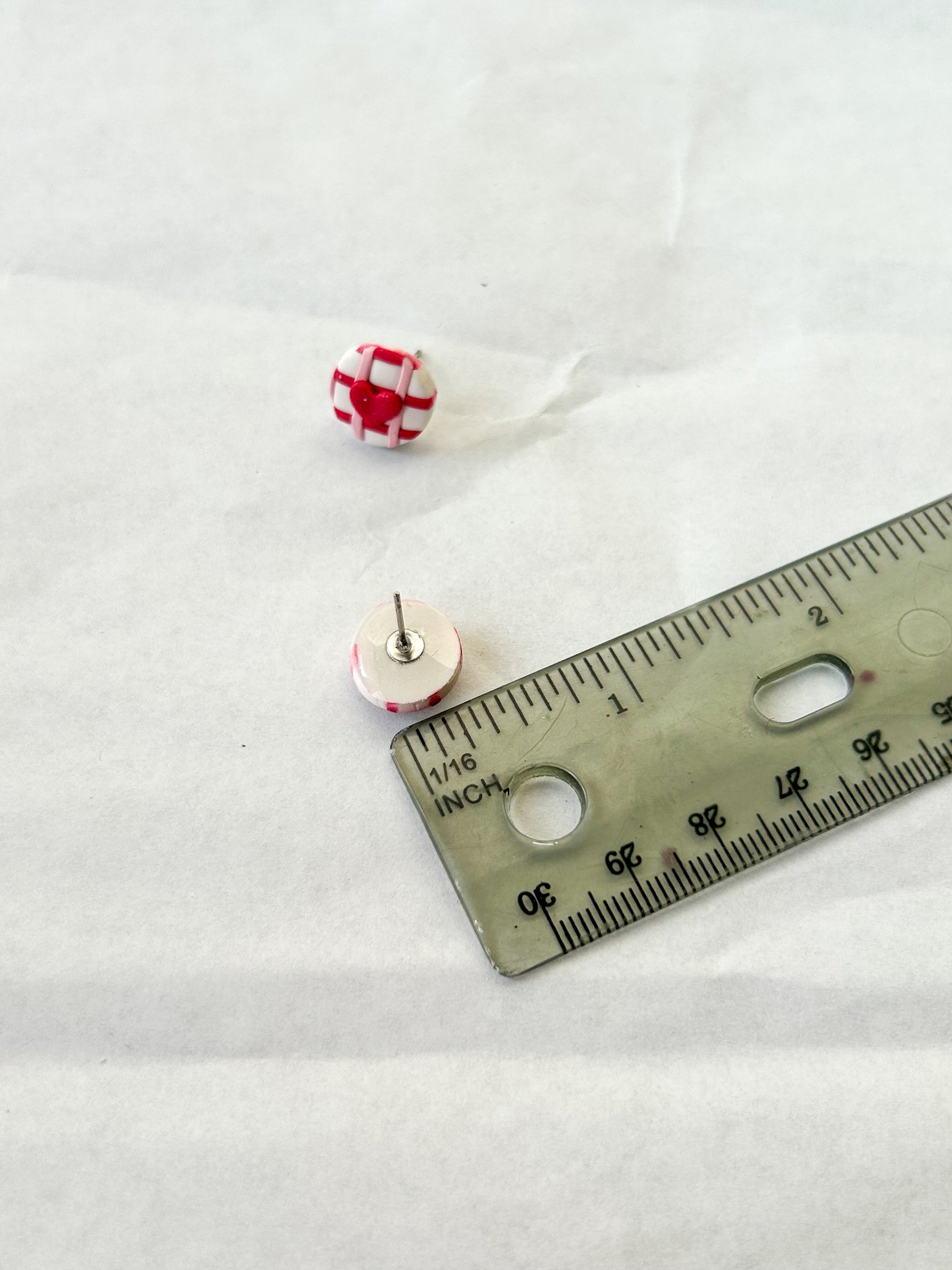 Stud earring next to a ruler to show that it is about 1/2 of an inch in length