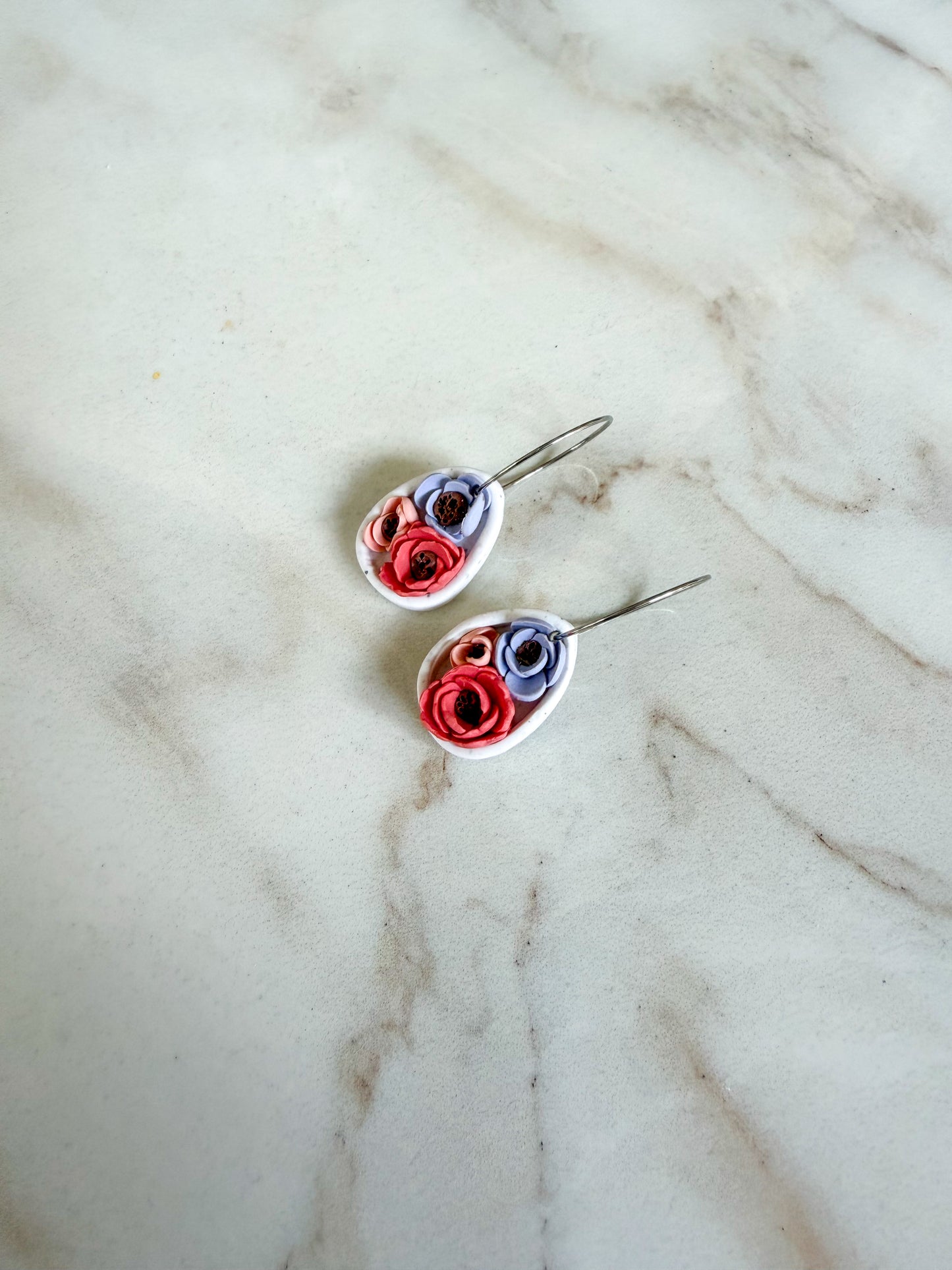 Pair of floral earrings on a marble surface