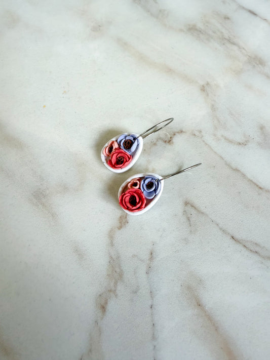 Pair of floral earrings on a marble surface
