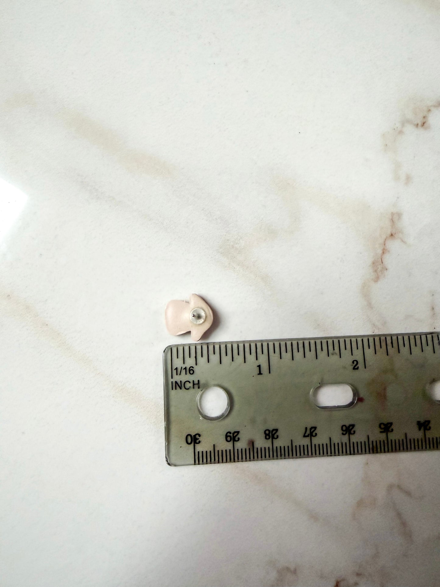 Small mushroom stud next to a ruler for scale. About 1/2 inch long. 