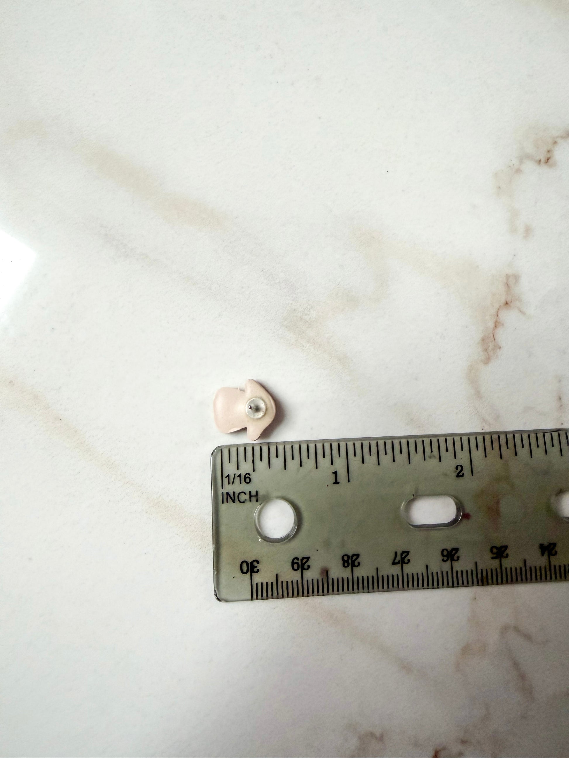 Small mushroom stud next to a ruler for scale. About 1/2 inch long. 