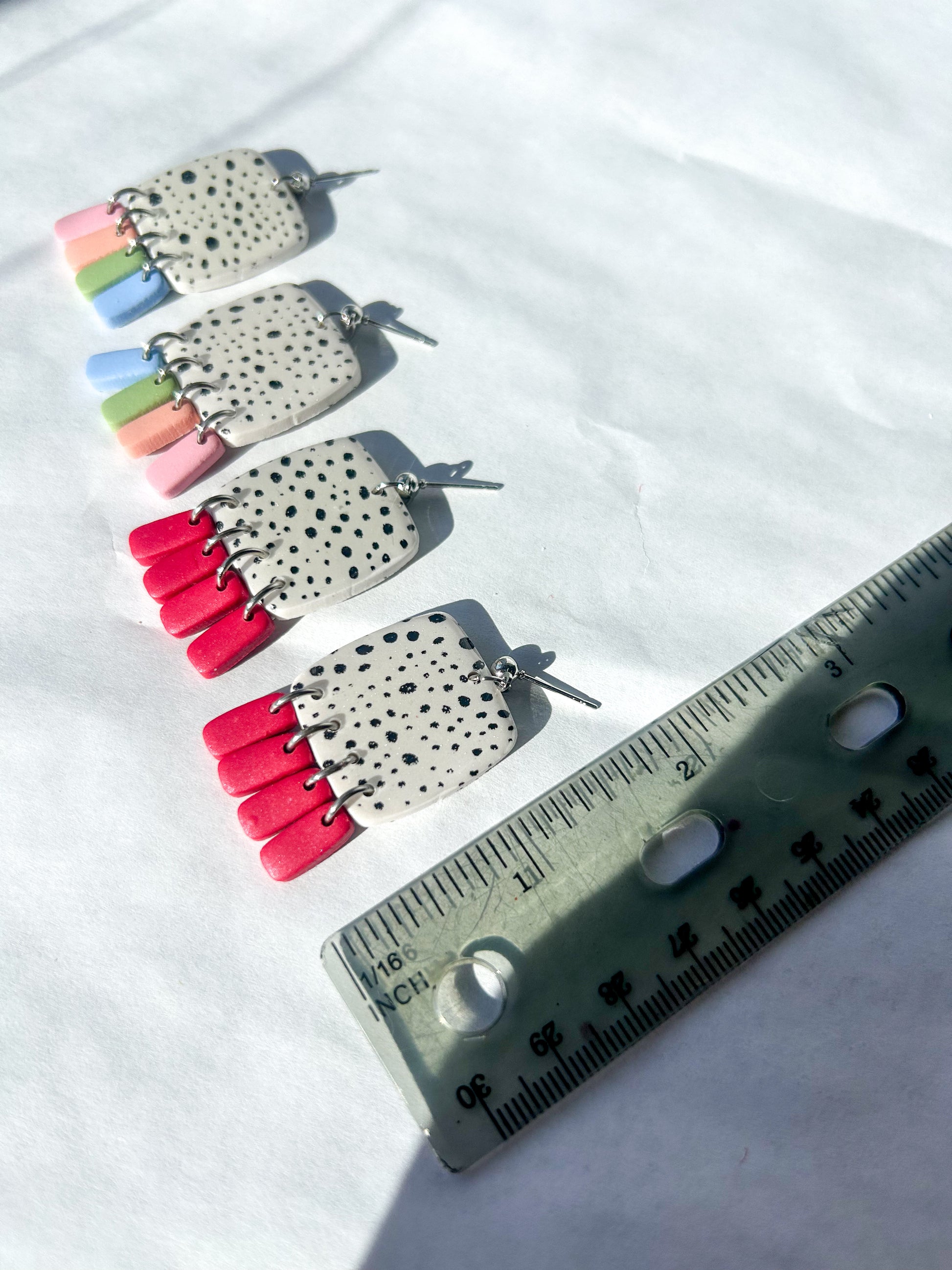 Pair of earrings sitting next to a ruler to show that it is approximately 1.75 inches long