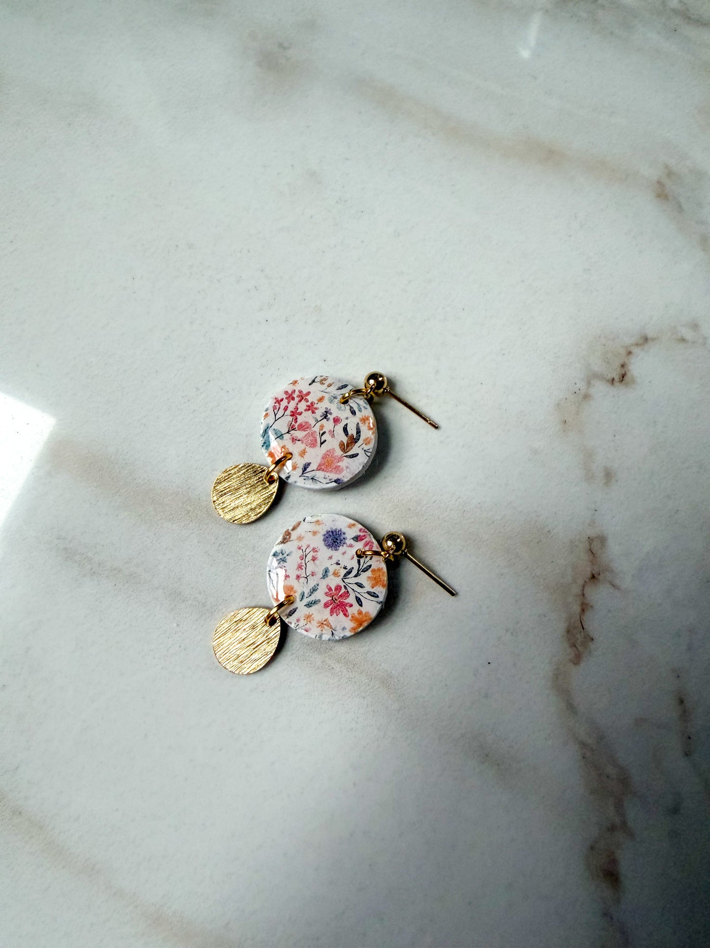 Floral earrings on a marble surface