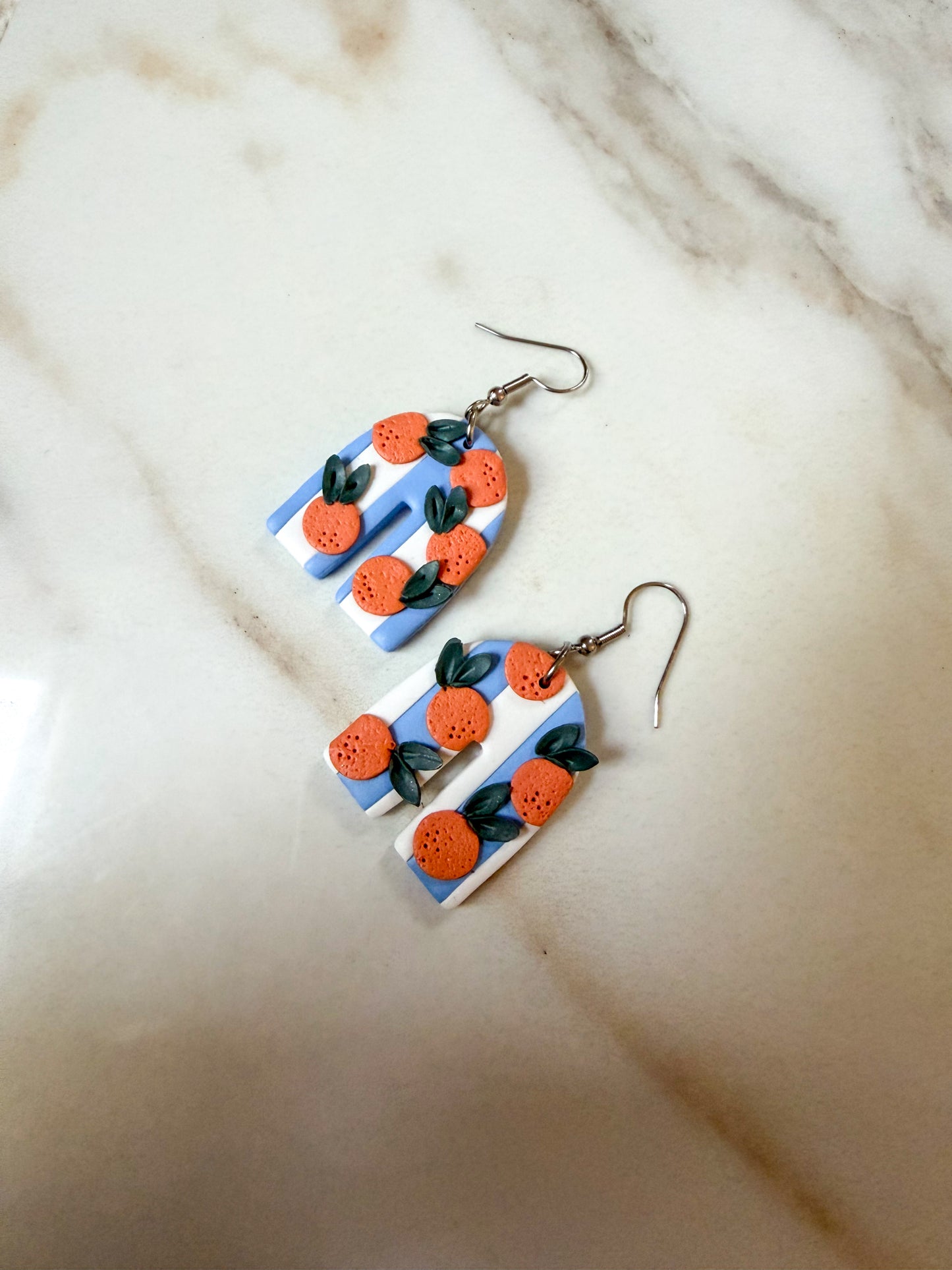 White and blue striped arches with oranges patterned on top. Hypoallergenic stainless steel hooks. 