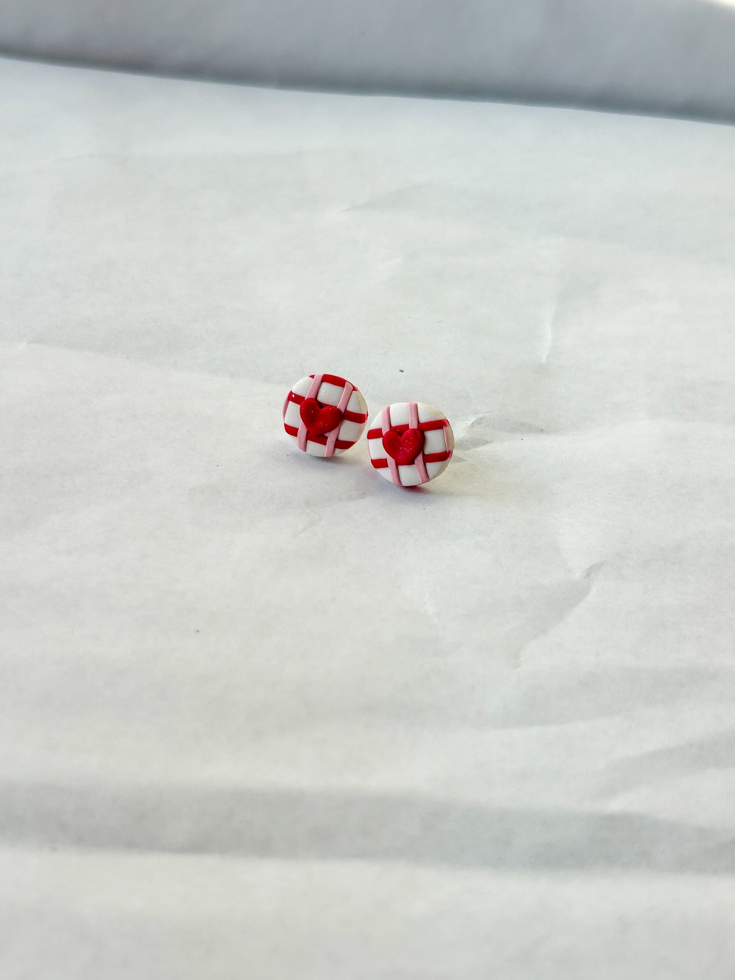 Red and white checkered earrings on a white surface