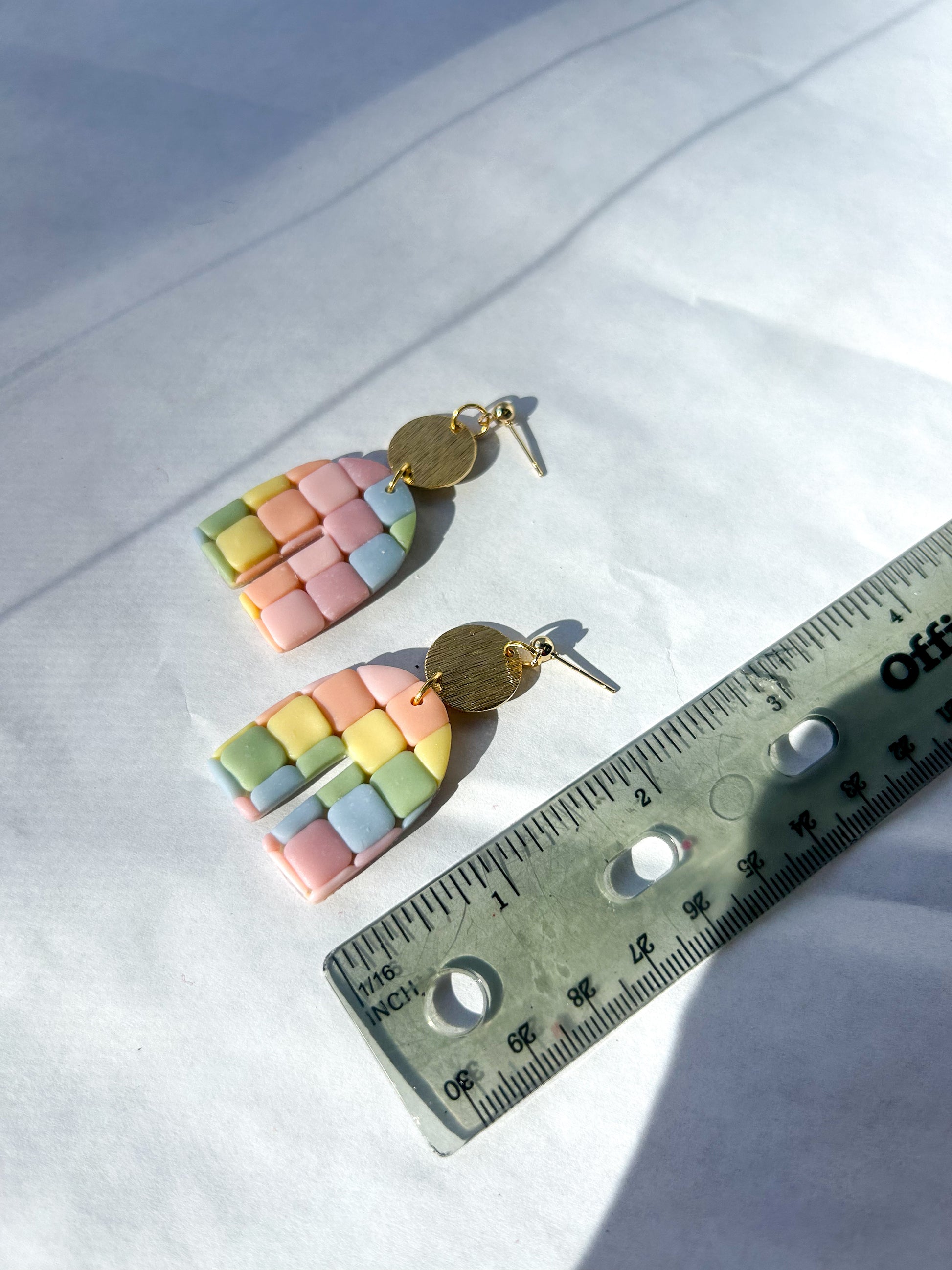 Pastel checkered earrings with gold accents on a white background, measured by a ruler. 2 inches in length 