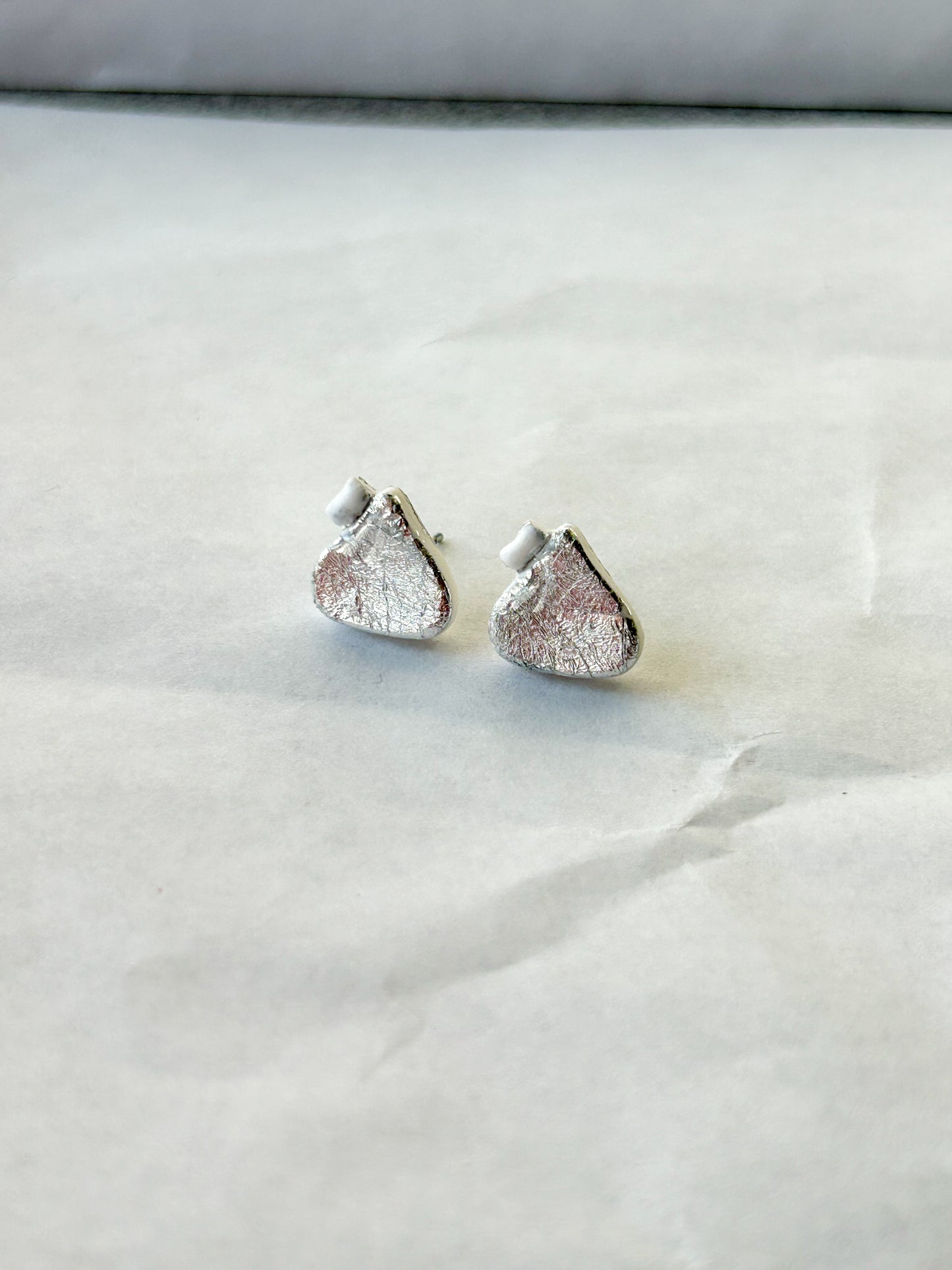 Silver earrings that look like chocolate candy drops