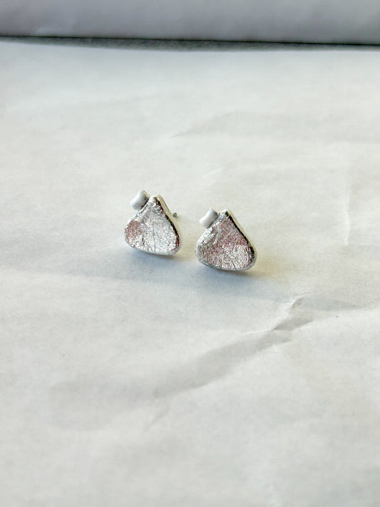 Silver earrings that look like chocolate candy drops
