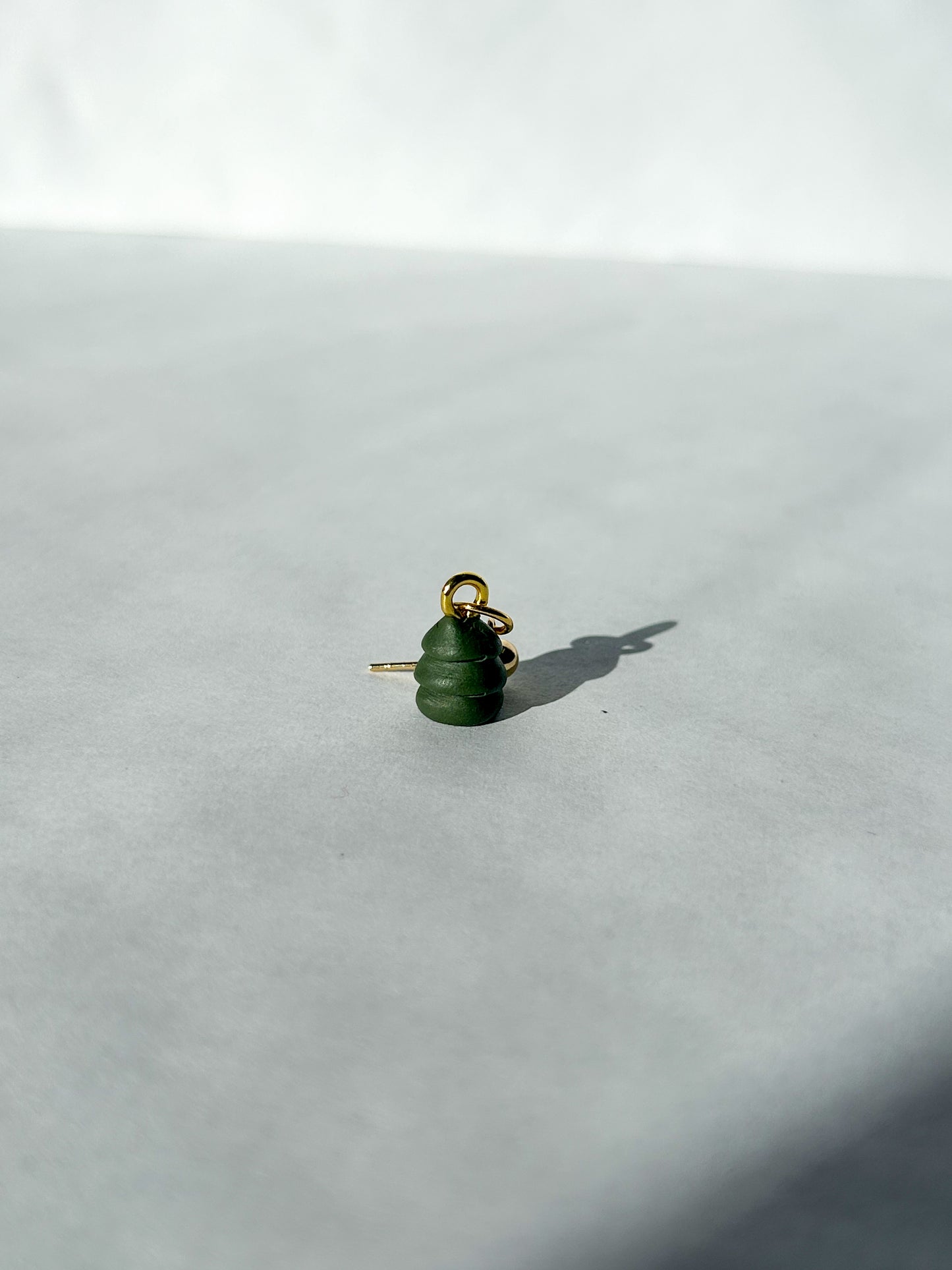 Green Christmas tree charm with gold ball post on a white background