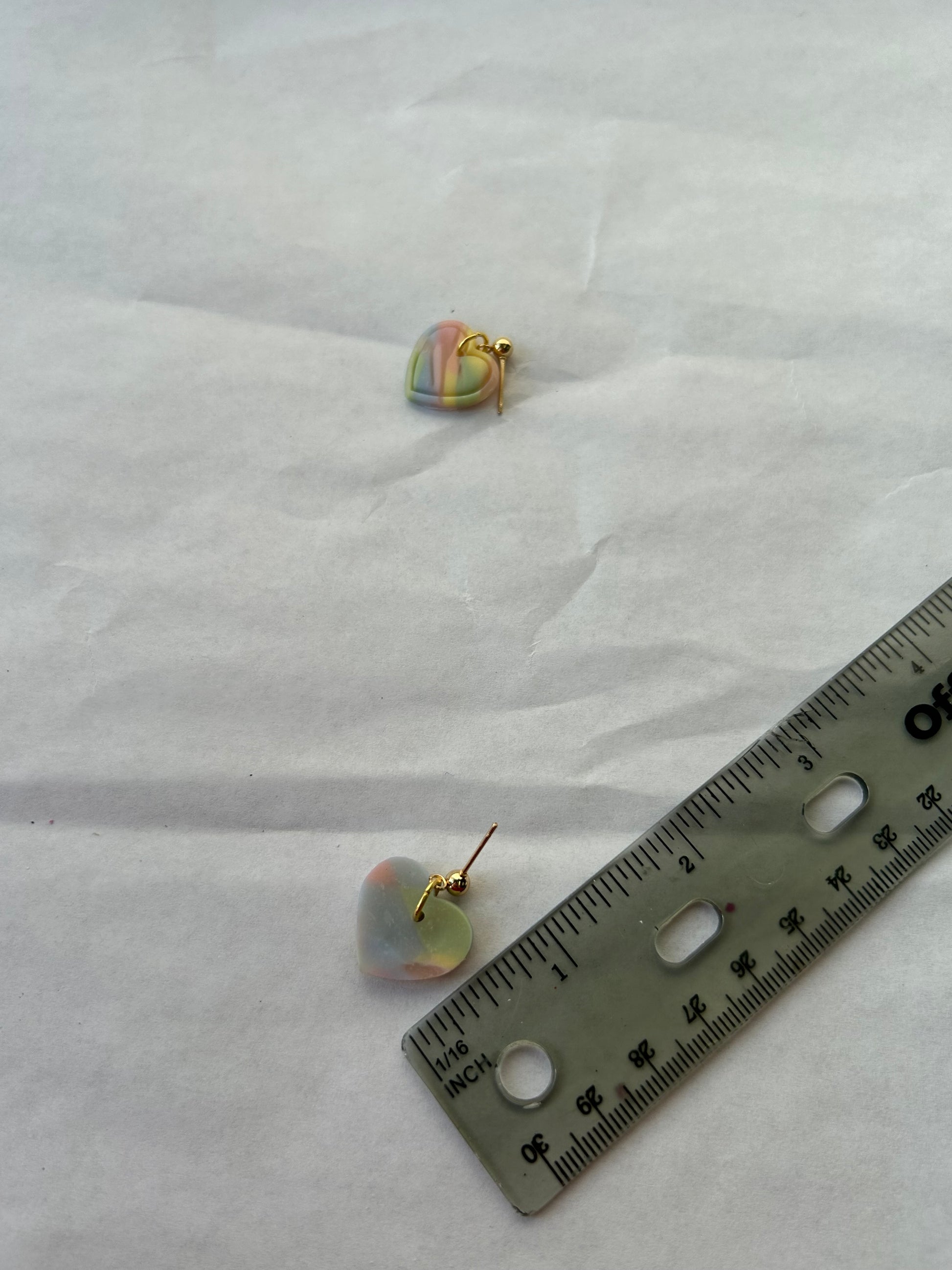 Pair of earrings with a ruler for scale on a white background
1 inch in length