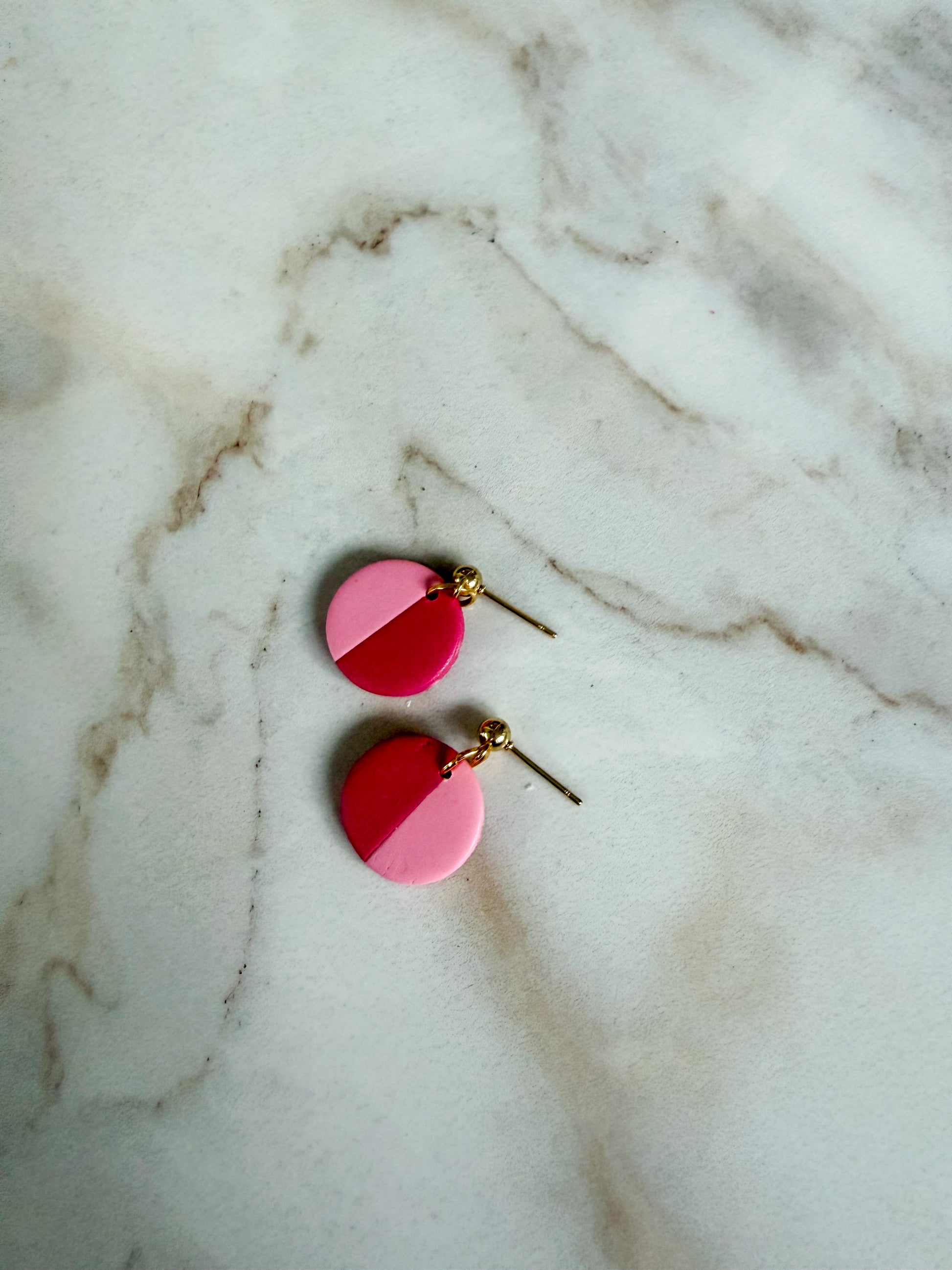 Pink circle earrings on a marble surface