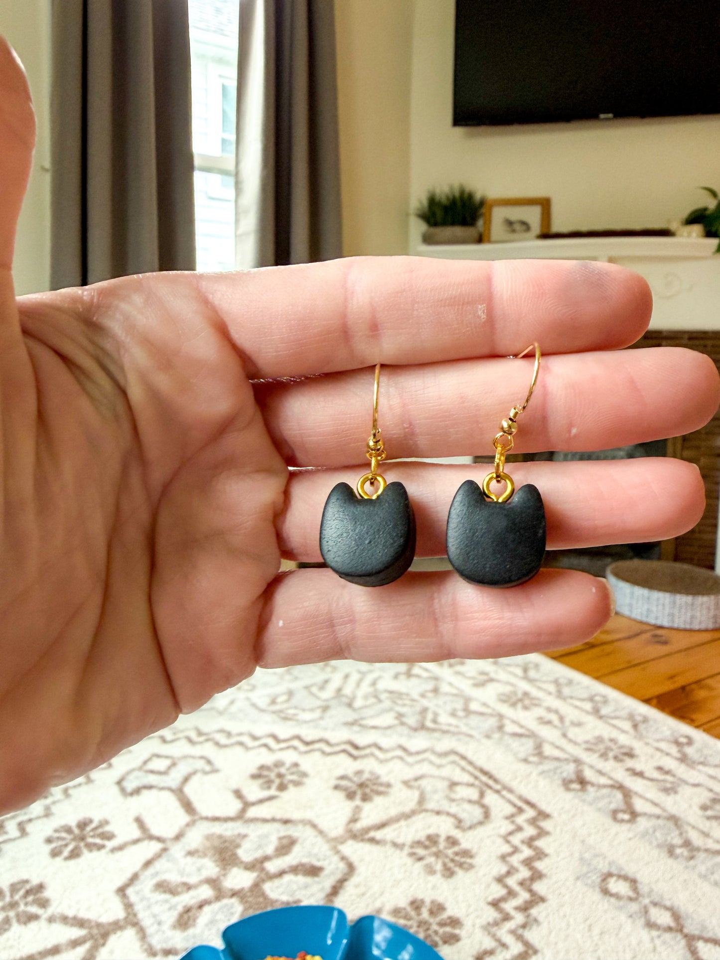 Black cat head shaped dangles on gold hooks. 