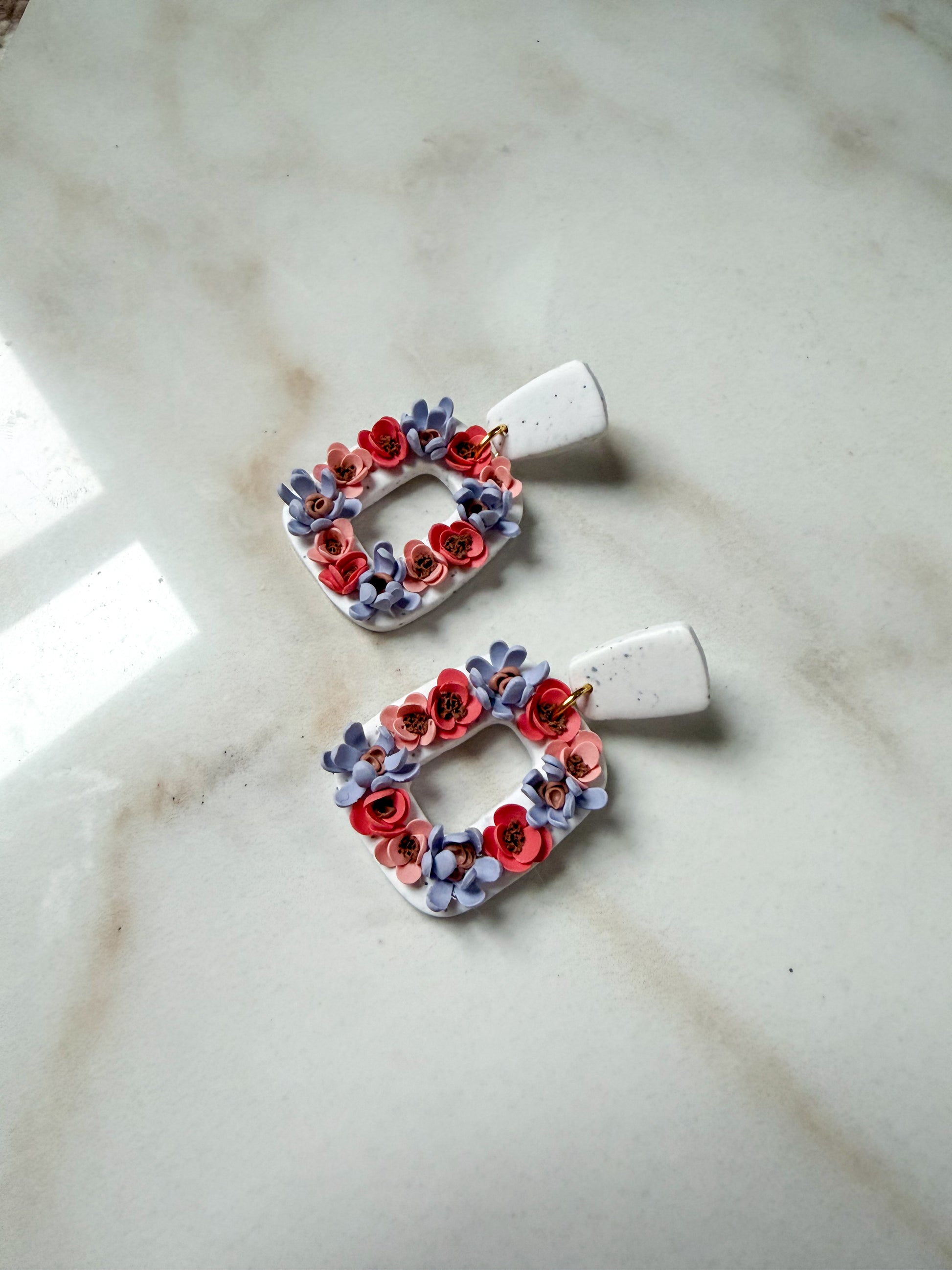 Pair of floral earrings on a marble surface